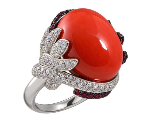 Make a bold statement with this exquisite red coral ring, featuring a striking oval coral centerpiece surrounded by dazzling diamonds. Intricate leaf-inspired diamond detailing enhances the design, while rich red accent gemstones add depth and contrast. A luxurious blend of vibrant color, exceptional craftsmanship, and timeless elegance, this distinctive piece is designed to captivate and stand out.